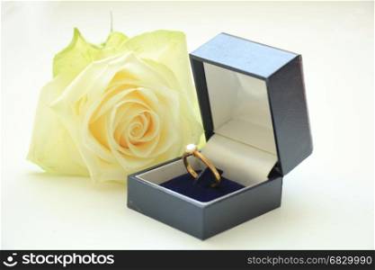 Engagement ring in box and ivory white rose