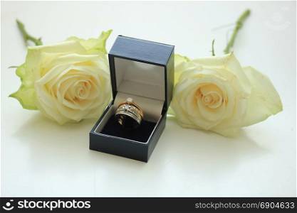 Engagement rings in boxes and white rose