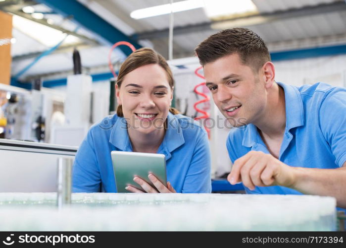 Engineer And Apprentice With Digital Tablet Working In Bottle Capping Factory