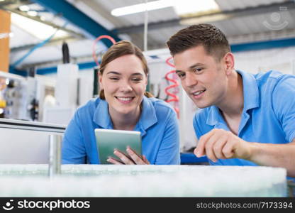 Engineer And Apprentice With Digital Tablet Working In Bottle Capping Factory