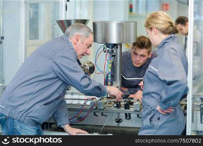 engineer and apprentices using automated milling machine