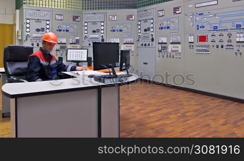 engineer approaches main control shield of gas compressor station and checks LEDs