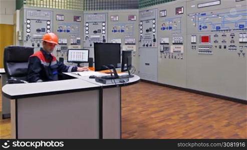 engineer approaches main control shield of gas compressor station and checks LEDs