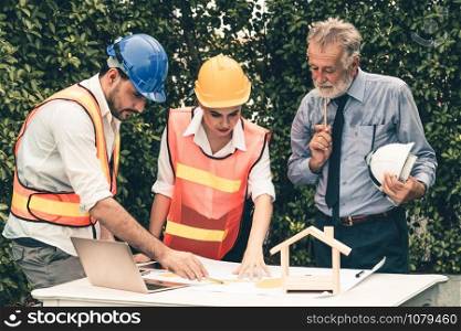 Engineer, architect and business man working on the engineering project at construction site. House building concept.