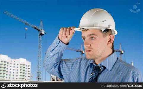 Engineer at white helmet on building background