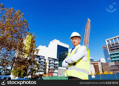 Engineer builder at construction site. Engineer builder wearing safety vest at construction site