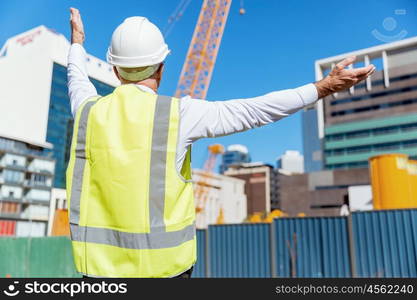 Engineer builder at construction site. Engineer builder wearing safety vest at construction site