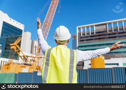 Engineer builder at construction site. Engineer builder wearing safety vest at construction site