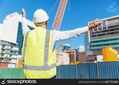 Engineer builder at construction site. Engineer builder wearing safety vest at construction site