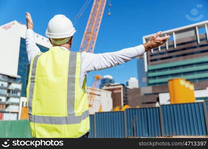 Engineer builder at construction site. Engineer builder wearing safety vest at construction site