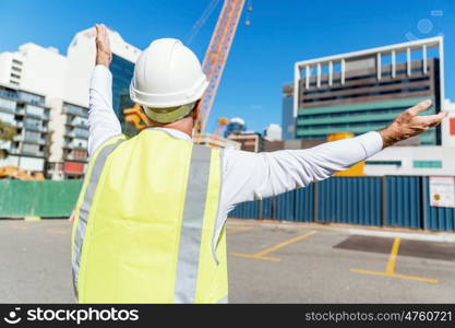 Engineer builder at construction site. Engineer builder wearing safety vest at construction site