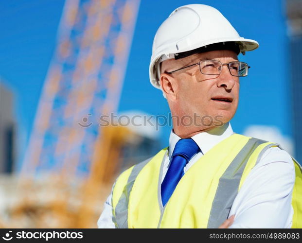 Engineer builder at construction site. Engineer builder wearing safety vest at construction site