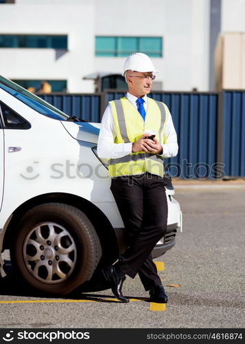 Engineer builder at construction site. Engineer builder wearing safety vest with coffee at construction site