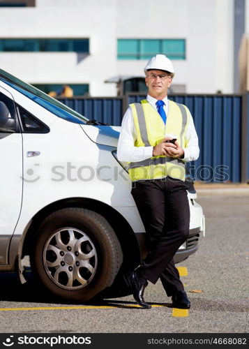 Engineer builder at construction site. Engineer builder wearing safety vest with coffee at construction site