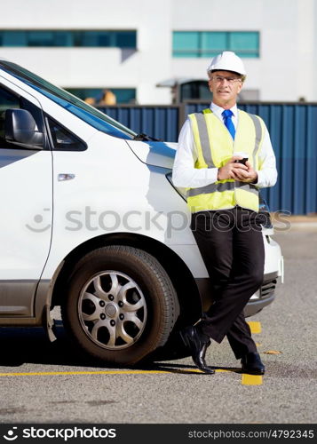 Engineer builder at construction site. Engineer builder wearing safety vest with coffee at construction site