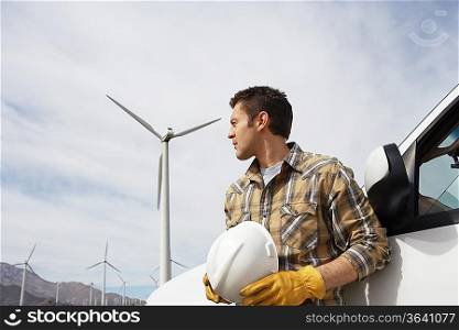 Engineer by car at wind farm