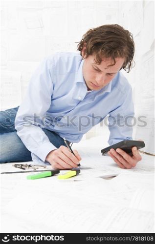 Engineer calculating the measurements of technical drawings, making notes with a pencil