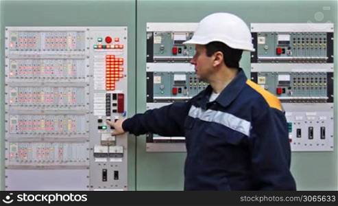 engineer checks light indication on two control panels