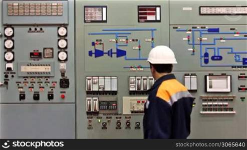 engineer comes to checking light indication on main control panel of compressor station
