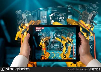Engineer controls robotic arms by augmented reality industry technology application software. Smart robot machine in future factory working in concept of Industry 4.0 or 4th industrial revolution.