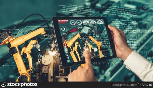 Engineer controls robotic arms by augmented reality industry technology application software. Smart robot machine in future factory working in concept of Industry 4.0 or 4th industrial revolution.. Engineer controls robotic arms by augmented reality industry technology