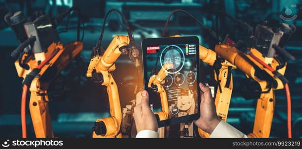 Engineer controls robotic arms by augmented reality industry technology application software. Smart robot machine in future factory working in concept of Industry 4.0 or 4th industrial revolution.. Engineer controls robotic arms by augmented reality industry technology