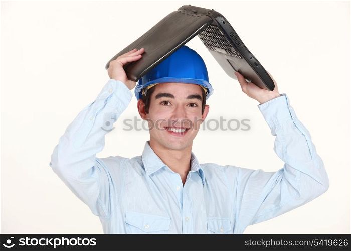 Engineer covering his head with a laptop