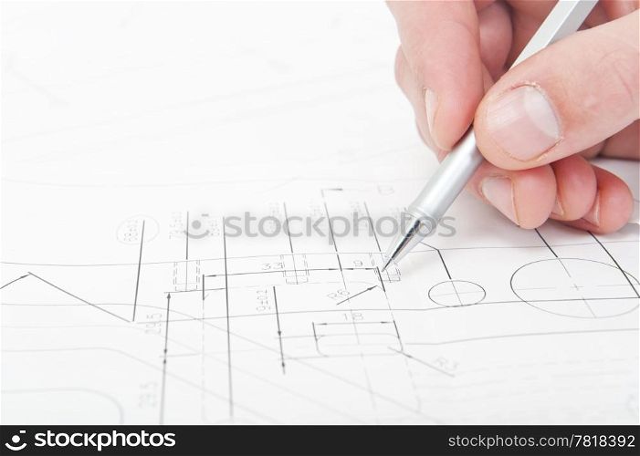 Engineer going over the fine details and measurements of a technical drawing with a pencil