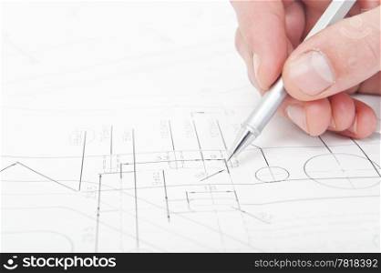 Engineer going over the fine details and measurements of a technical drawing with a pencil