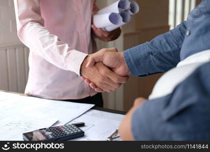 engineer handshaking. architect shaking hands for successful deal in building construction project. teamwork cooperation concept
