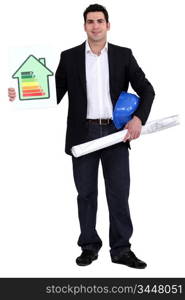 Engineer holding a hard hat, a rolled-up drawing and an energy efficiency rating sign