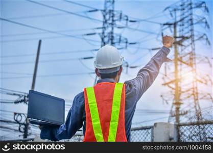 Engineer holding computer notebook high voltage power plant background