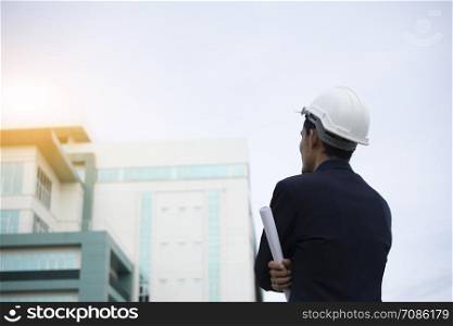 Engineer Holding paper plan and building Sky Background