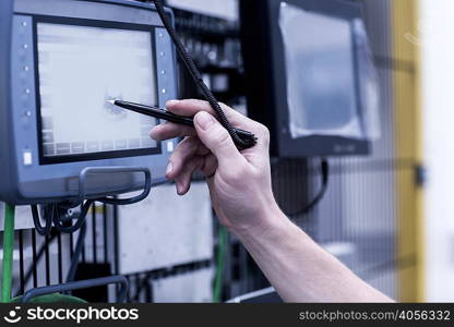 Engineer in engineering plant, using stylus on screen, close-up