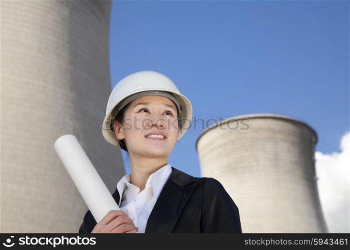 Engineer in front of cooling towers