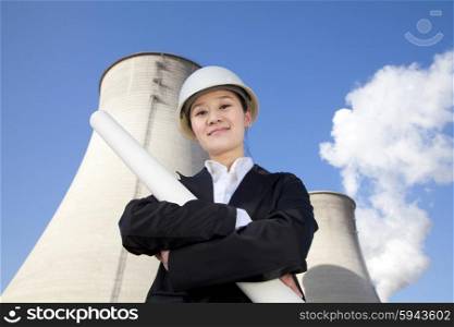 Engineer in front of cooling towers