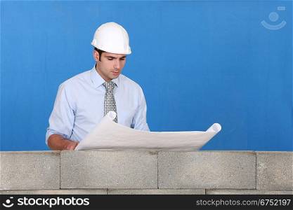 Engineer inspecting a construction blueprint