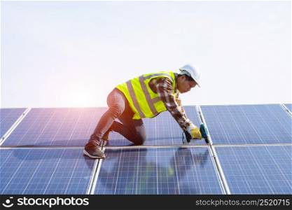 Engineer installing solar photovoltaic panel system using screwdriver,Installing photovoltaic panels on a metal basis on a solar farm.