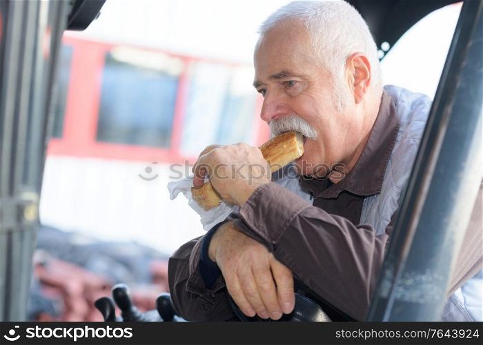 engineer is biting a sandwich in his lunch break