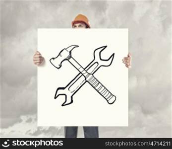 Engineer man with banner. Man in helmet showing white banner with tool concept