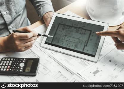 Engineer meeting and using digital tablet for architectural project and working with partner engineering on workplace