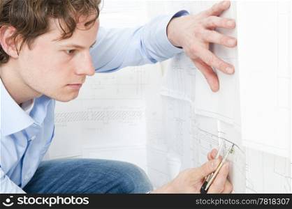 Engineer meticulously checking measurements on a technical drawing using a pair of compasses