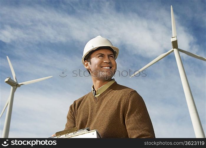 Engineer near wind turbines at wind farm