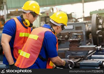 Engineer or mechanical worker with yellow safety helmet checking on production in a factory. Industrial, Mechanic, Engineering Concept.