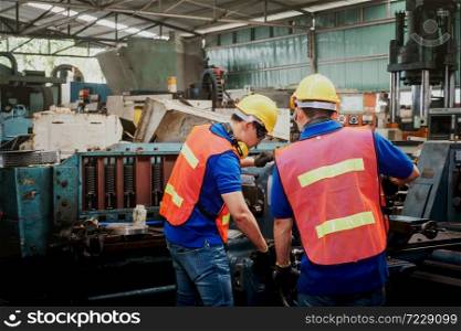 Engineer or mechanical worker with yellow safety helmet checking on production in a factory. Industrial, Mechanic, Engineering Concept.