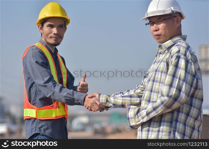 Engineer shake hand Foreman at construction site