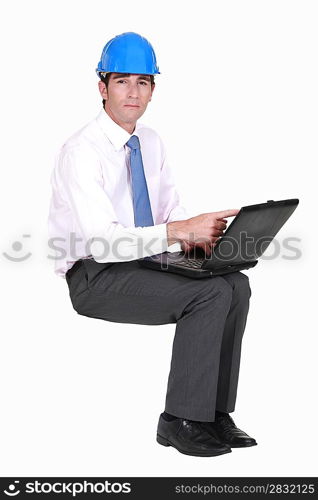 Engineer sitting in empty copyspace with a laptop