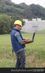 Engineer standing in front of dam under construction