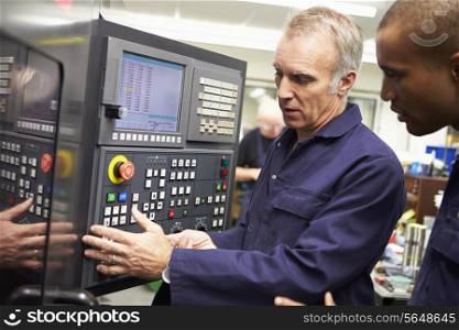 Engineer Teaching Apprentice To Use Computerized Lathe