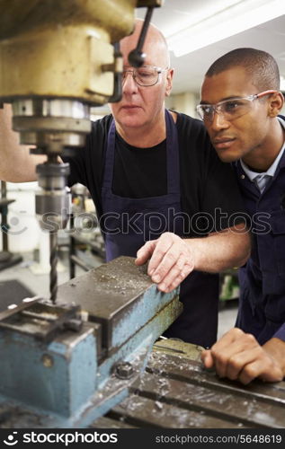 Engineer Teaching Apprentice To Use Milling Machine